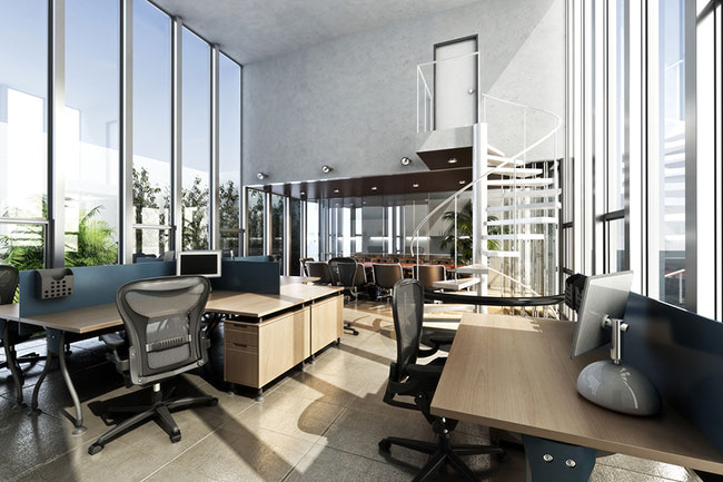 Ein modernes Büro mit hohen, bodentiefen Fenstern, die viel Tageslicht hereinlassen. Mehrere Schreibtische mit Computern und Bürostühlen sind im Raum verteilt, und eine weiße Wendeltreppe führt zu einer oberen Ebene mit weiteren Arbeitsplätzen.